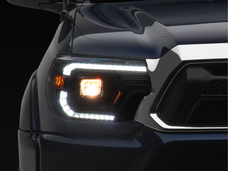 Raxiom 12-15 Toyota Tacoma Axial Series Switchback Projector Headlights- Black Housing- Clear Lens